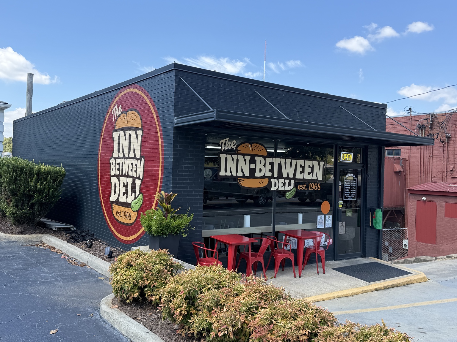 The Inn-Between Deli today, with its round wall mural and red outdoor tables